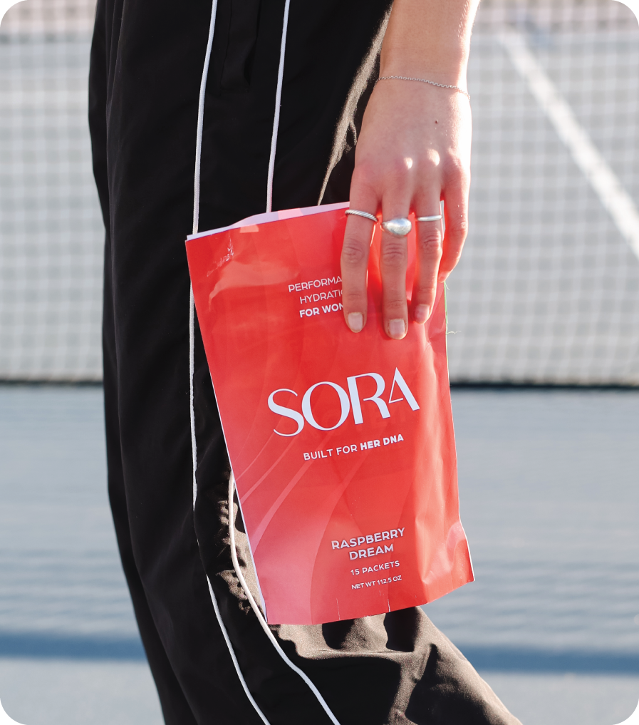 Person holding a red SORA product package with a blurred background
