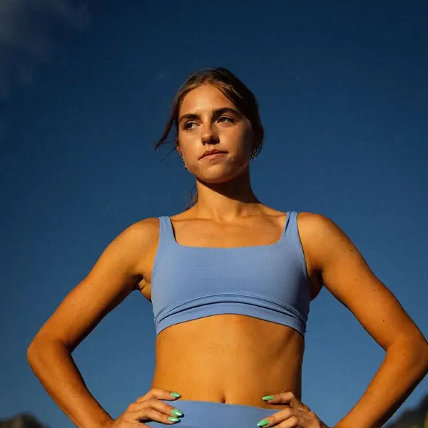 Confident female athlete on a track, hands on hips