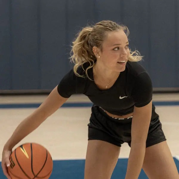Female basketball player dribbling on court